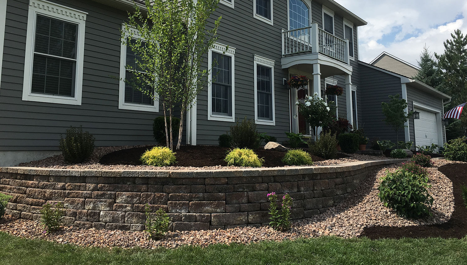 A rounded stone retaining wall at a Central New York home – sturdy enough to keep out invaders