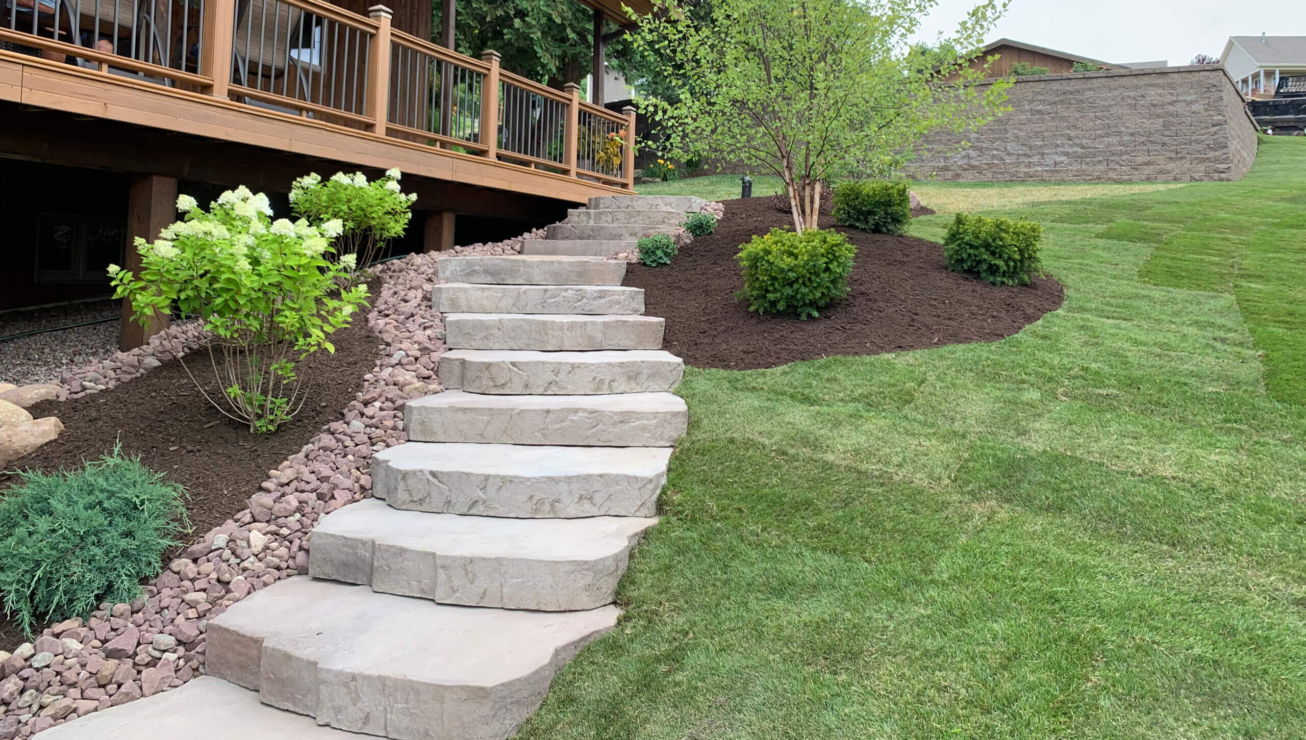 Stone steps cascading down a green grass hill at a central new york home